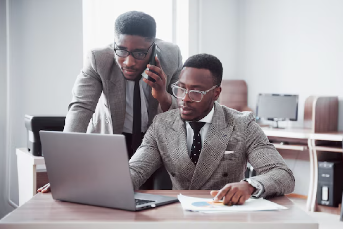 Deux personnes discutant d'investissement avec un ordinateur portable